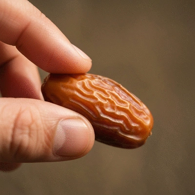 Close-up of a hand gently feeling the texture of a premium date