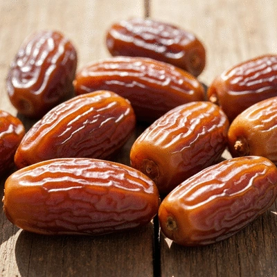 Close-up of fresh, plump dates on a rustic wooden surface