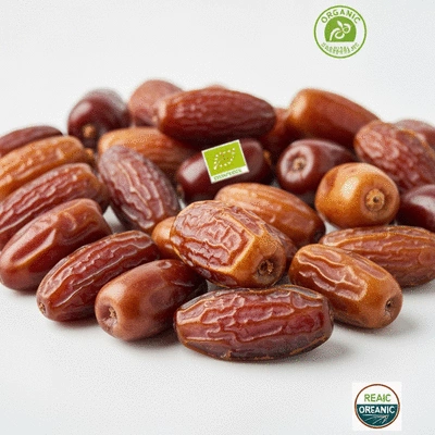 A close-up shot of various fresh dates on a clean white background, showcasing their natural textures and colors, with some organic certification labels subtly visible.